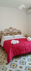 a bedroom with a red bed with towels on it at Villa Orchidea in Praia a Mare +17 photos