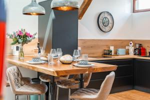 a kitchen with a wooden table and chairs at Loft Cosy et atypique in Sévrier