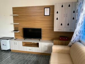 a living room with a couch and a television at XD Hotels 101 in Bangalore
