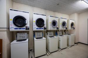 a row of washers and dryers in a room at ホテルグランフォーレ in Shikokuchuo