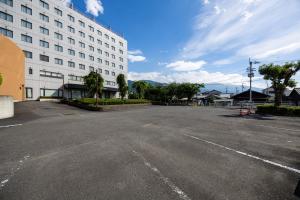 an empty parking lot in front of a building at ホテルグランフォーレ in Shikokuchuo