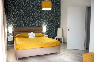 a bedroom with a yellow bed with a teddy bear on it at B & B Victoria in Pompei