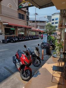 a row of motorcycles parked in a parking lot at DelMar by Mery World Hospitality in Pattaya South