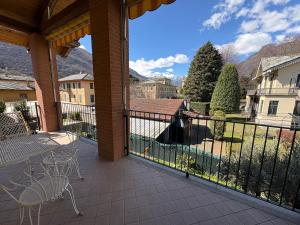 a patio with a table and chairs on a balcony at Casa Emma in Torre Pellice