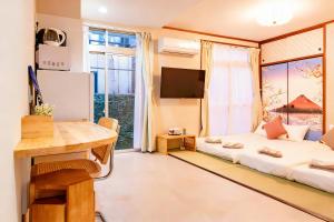 a living room with a bed and a large window at Court Ada -1min to Araiyakushi-mae Station, 9min train to Shinjuku- 新井薬師前駅徒歩50秒 in Tokyo