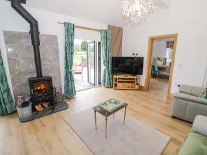 a living room with a fireplace and a tv at The Barn in Redditch