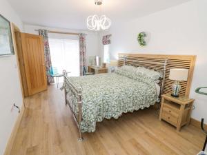 a bedroom with a bed and a chandelier at The Barn in Redditch