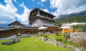 ein großes Gebäude mit einem Rasen davor in der Unterkunft Wellness Hotel Bladen in Sappada + 69 Fotos