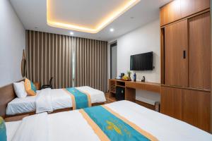 a hotel room with two beds and a television at New Sky Light Villa in Dong Hoi +41 photos