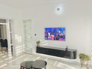 a living room with a tv on a wall at His Goodness - Apt 2 in Katale