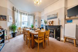 a dining room with a table and chairs and a fireplace at Mariners Guest House in Plymouth