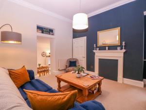 a living room with a couch and a table at Stylish Town Apartment in Ross on Wye