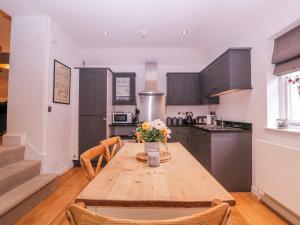 a kitchen with a wooden table with flowers on it at Stylish Town Apartment in Ross on Wye