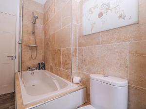 a bathroom with a tub and a toilet and a sink at Stylish Town Apartment in Ross on Wye +17 photos