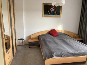 a bedroom with a bed with a red pillow on it at Huber Hof in Oberrosenauerwald