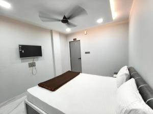 a bedroom with a white bed with a ceiling fan at Hotel Rudra in Wākal