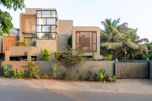 a building with palm trees in front of it at Lindsay Manor Santo Sovrano 4BHK Heated Pool in Vagator