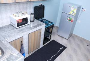 a kitchen with a microwave and a refrigerator at Gee Homes and Stays in Nyahururu +2 photos