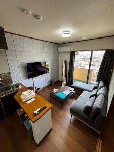 a living room with a couch and a table at Stay Plus Azunoa in Oyama