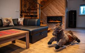 a horse laying on the floor in a living room at Domki Perła Białki z Jacuzzi in Białka Tatrzańska