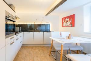 a kitchen with white cabinets and a table and chairs at Ferienhaus Achtern Diek in Hemme