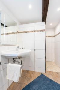 a white bathroom with a sink and a shower at Ferienhaus Achtern Diek in Hemme +10 photos