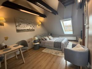 a bedroom with a bed and a table and a couch at Vila Preiloja in Neringa