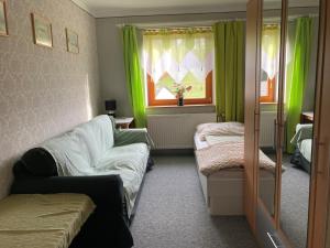 a room with a couch and a window with green curtains at Huber Hof in Oberrosenauerwald