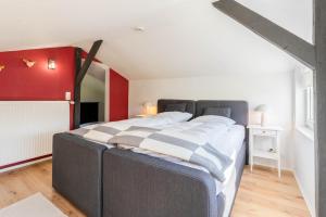 a large bed in a room with a red wall at Ferienhaus Achtern Diek in Hemme