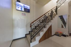 a staircase in a building with a tv on the wall at Wisma Brata 2 Mitra RedDoorz in Nyomolong