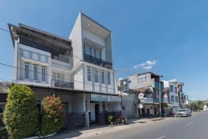 a white building on the side of a street at Wisma Brata 2 Mitra RedDoorz in Nyomolong