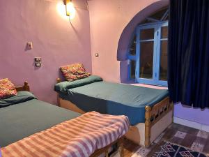 a room with two twin beds and a window at Amir Nile Guest house in Aswan