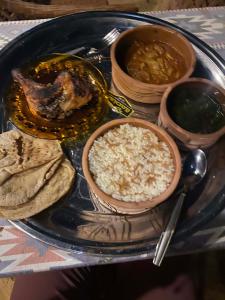 a plate of food with rice and beans and dips at Amir Nile Guest house in Aswan +21 photos