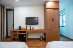 a room with a desk with a tv and a cabinet at New Sky Light Villa in Dong Hoi