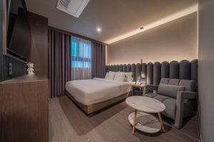 a hotel room with a bed and a couch at Gyeongju Poverta Hotel in Gyeongju
