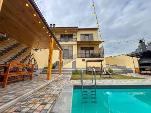 a house with a swimming pool in front of a building at Miracle View Dilijan in Dilijan