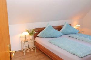 a bedroom with a bed with blue pillows at Ferienhaus Minners in Jork