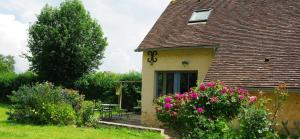 a house with a clock on the side of it at Jardin Solstice in Vaupillon