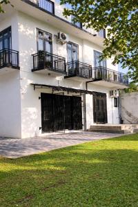 a white building with black gates and a grass yard at Nisansala Villa in Matara