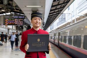 a man standing in a train station holding a laptop at Shangri-La Tokyo in Tokyo