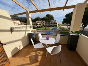 ein Balkon mit Tisch und Stühlen und ein Pool in der Unterkunft Punta Atico in Alcanar