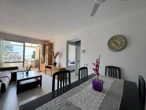 ein Wohnzimmer mit einem Tisch und einer Uhr an der Wand in der Unterkunft Punta Atico in Alcanar