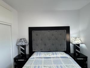 ein Schlafzimmer mit einem Bett und zwei Lampen auf Tischen in der Unterkunft Punta Atico in Alcanar