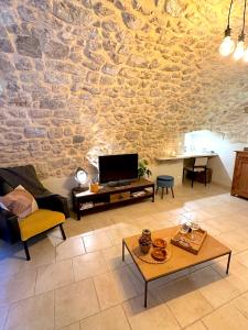 a living room with a stone wall at Gîte de charme au pied du Château de Brissac in Brissac