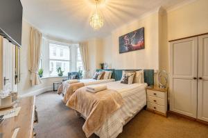 a bedroom with two beds and a chandelier at Mariners Guest House in Plymouth