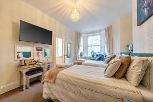 a bedroom with a large bed with a television on the wall at Mariners Guest House in Plymouth