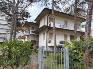 a white house with a fence in front of it at Hotel Soraya & Apartments in Lignano Sabbiadoro