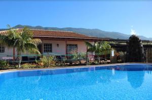 a large blue swimming pool in front of a house at Casa la Majada in Los Llanos de Aridane