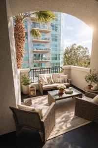 a balcony with chairs and a couch and a building at Modern 1 & 2 Bedroom Apartments Near Venice & MDR with Pool Gym & Cinema in Los Angeles