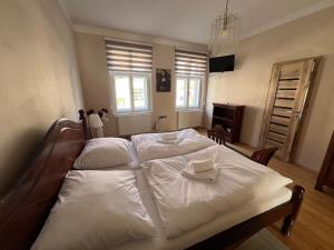 a large white bed with two white towels on it at Apartmán pod věží Jevíčko in Jevíčko